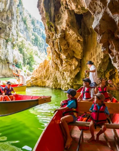 Famille faisant une balade en barque avec les Bateliers de l'Ardèche en été, au Pont d'Arc, dans les Gorges de l'Ardèche