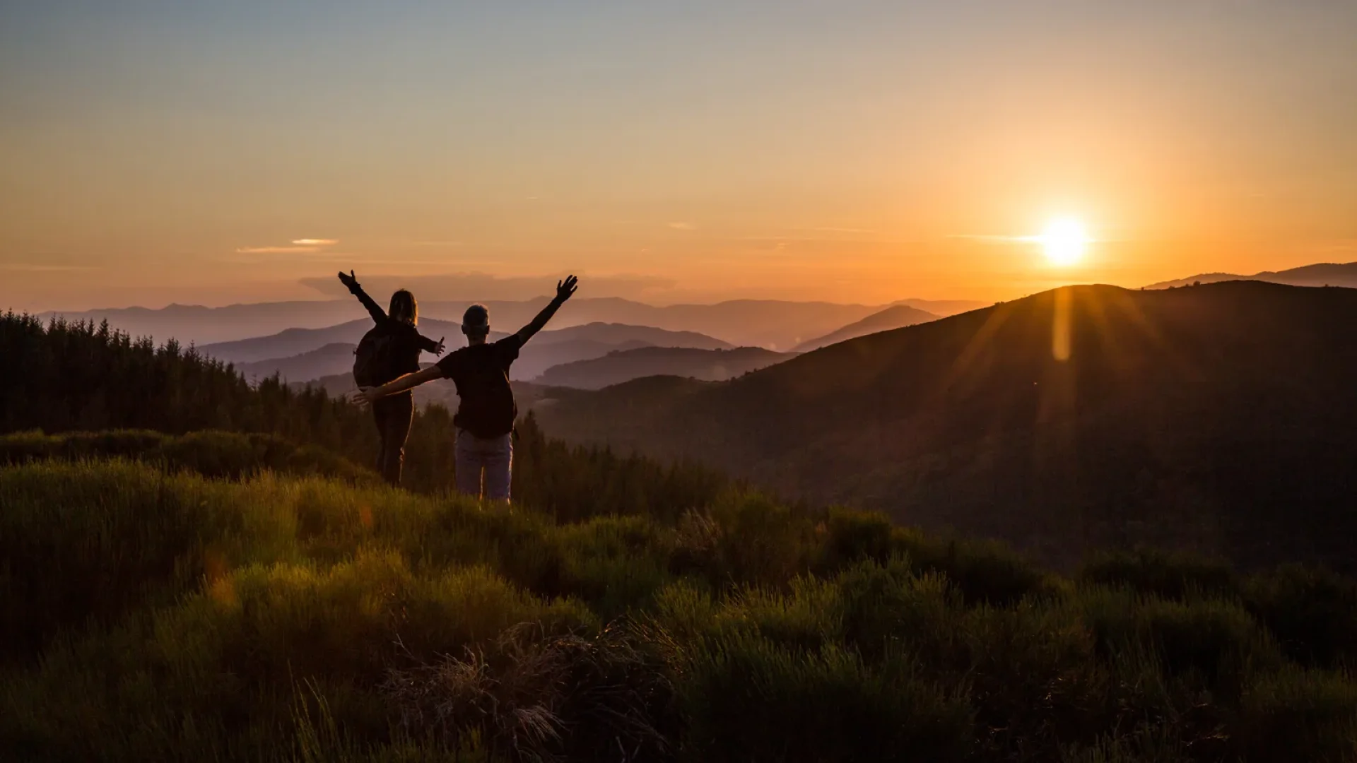 Couple saluant le coucher de soleil et la fin de leur randonnée en été