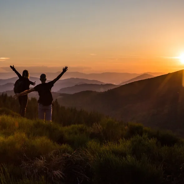 Couple saluant le coucher de soleil et la fin de leur randonnée en été