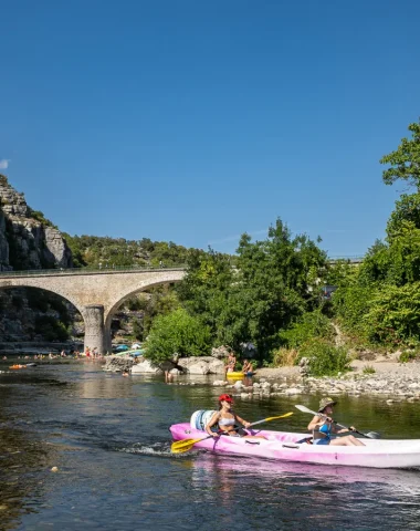 Femmes en canoé au niveau du village de caractère de Balazuc, en été