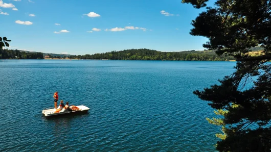 Famille faisant du pédalo au lac d'Issarlès en été