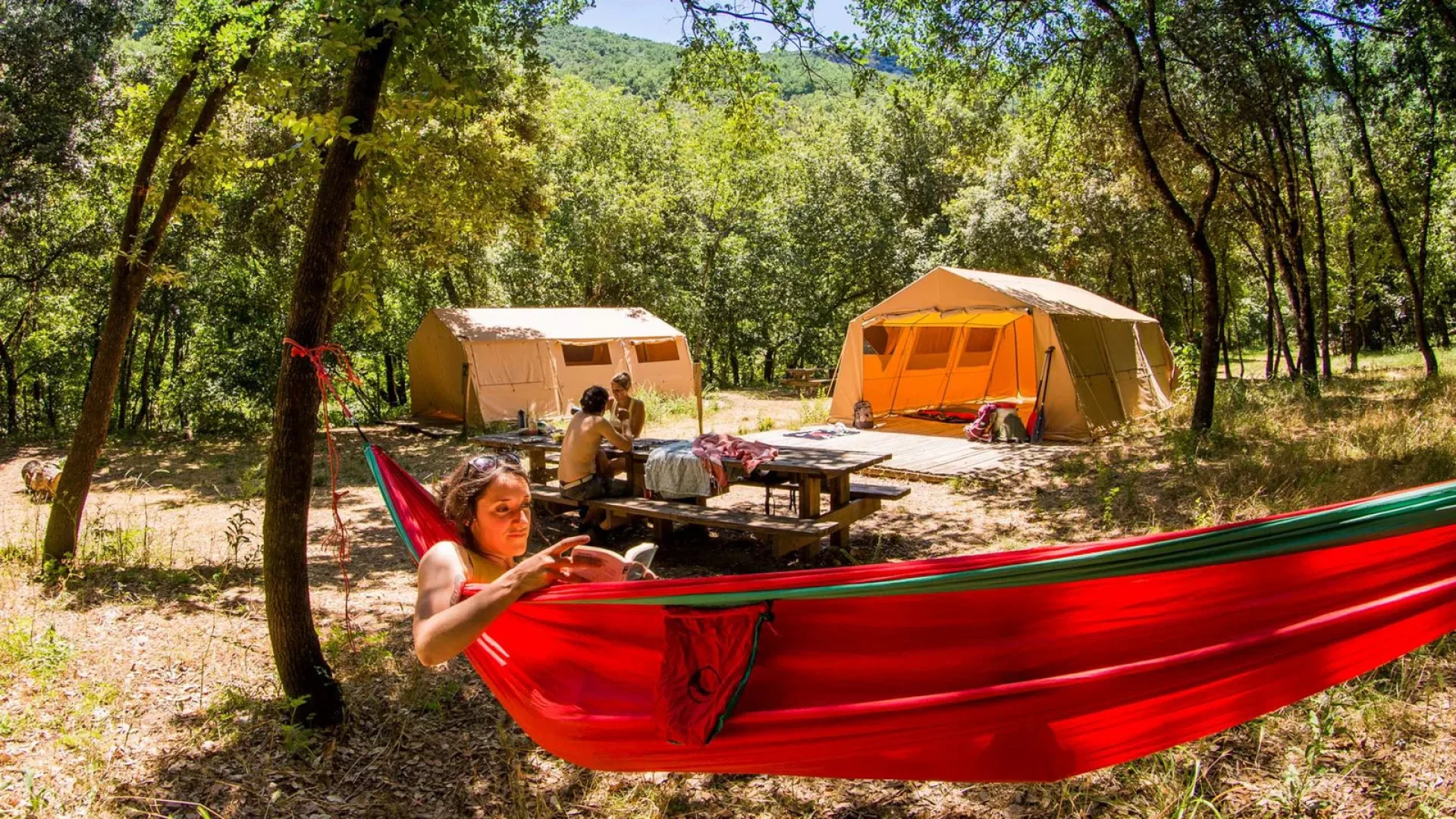 Femme se détendant dans un hamac lors d'un bivouac dans les Gorges de l'Ardèche, en été