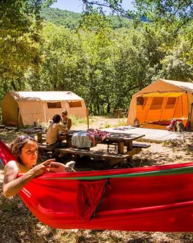 Femme se détendant dans un hamac lors d'un bivouac dans les Gorges de l'Ardèche, en été