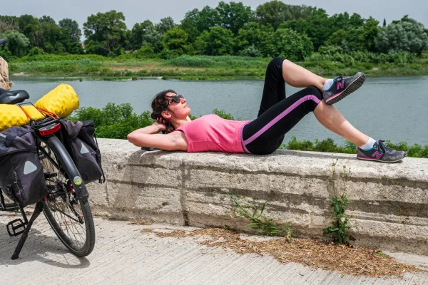 Femme en itinérance à vélo sur la ViaRhôna, faisant une pause, en été