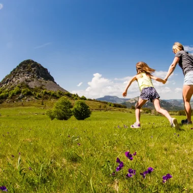 Famille qui coure vers le Mont-Gerbier-de-Jonc au printemps