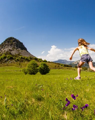 Famille qui coure vers le Mont-Gerbier-de-Jonc au printemps