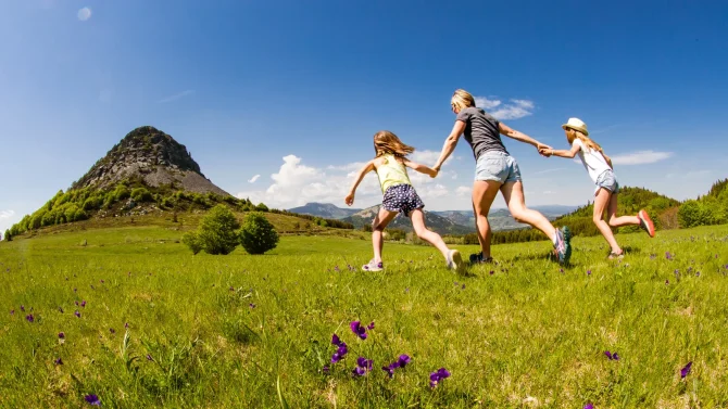 Famille qui coure vers le Mont-Gerbier-de-Jonc au printemps